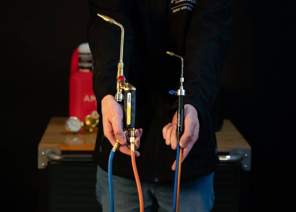 A photo of the Oxyset welding torch (left) and the precision torch (right) in hands